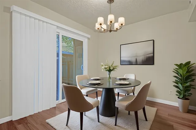 a view of a dining room with furniture wooden floor and chandelier