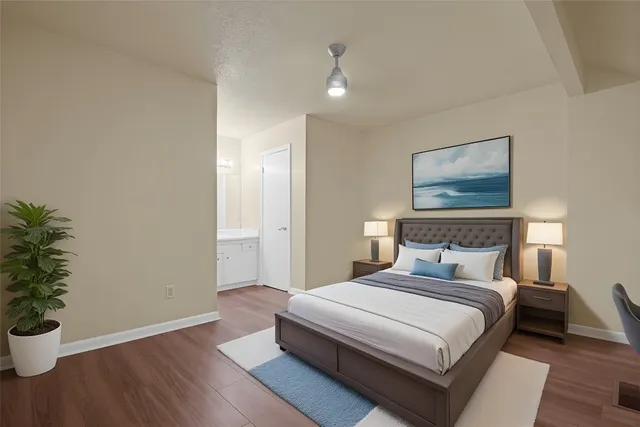 a bedroom with a large bed and a potted plant