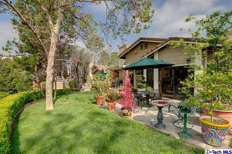 2031 Rosemont Avenue, Unit 2 Pasadena, CA 91103 - Photo 28 of 33 a backyard of a house with table and chairs under an umbrella