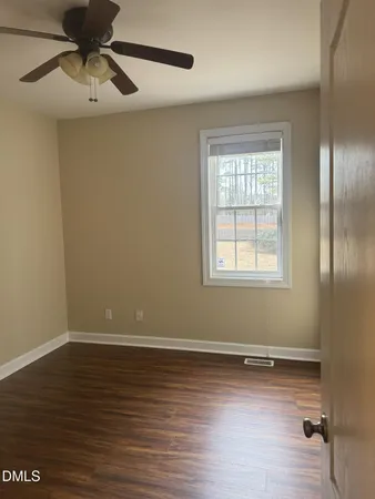 a view of a room with wooden floor closet chandelier fan and windows