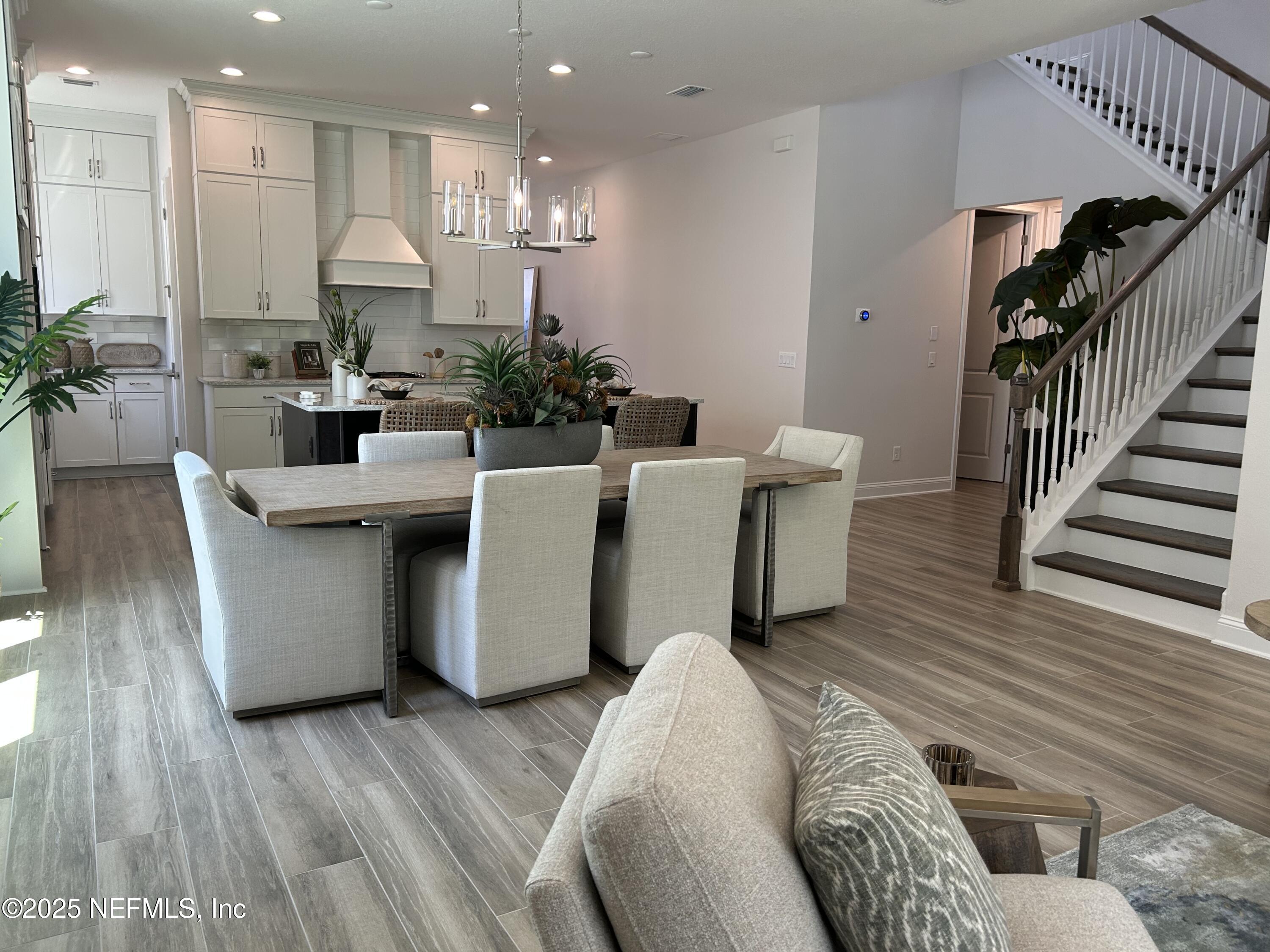 486 Navigators Road St. Johns, FL 32259 - Photo 13 of 22 a living room with furniture a wooden floor and a chandelier
