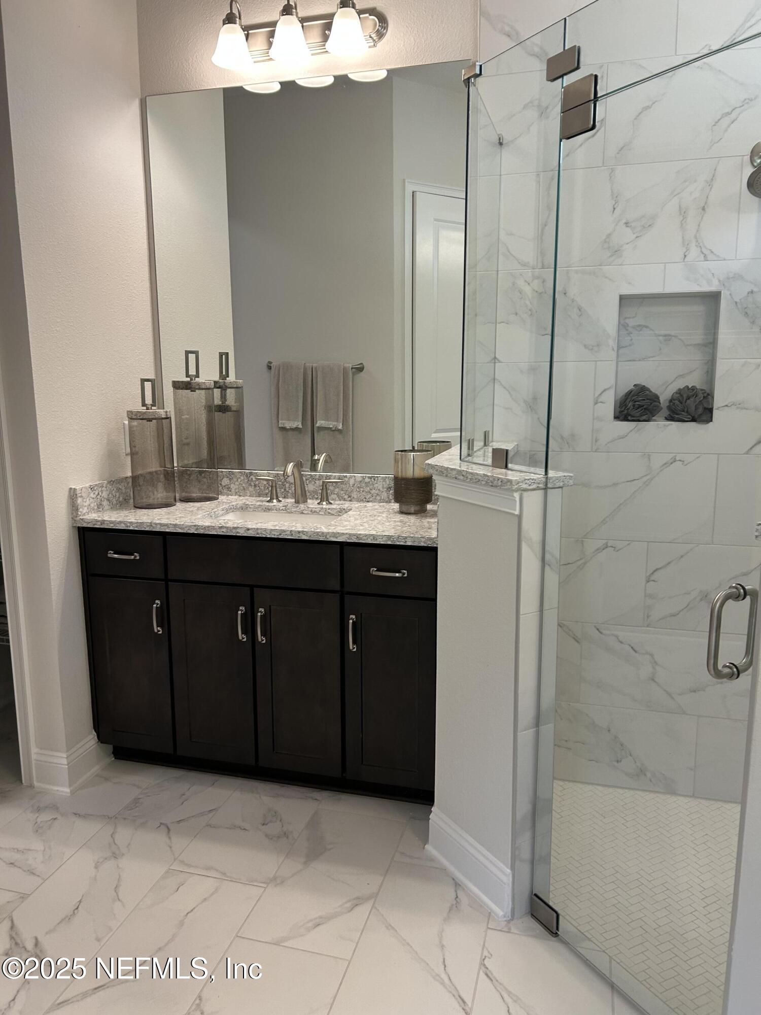 486 Navigators Road St. Johns, FL 32259 - Photo 16 of 22 a bathroom with a granite countertop sink a mirror and shower
