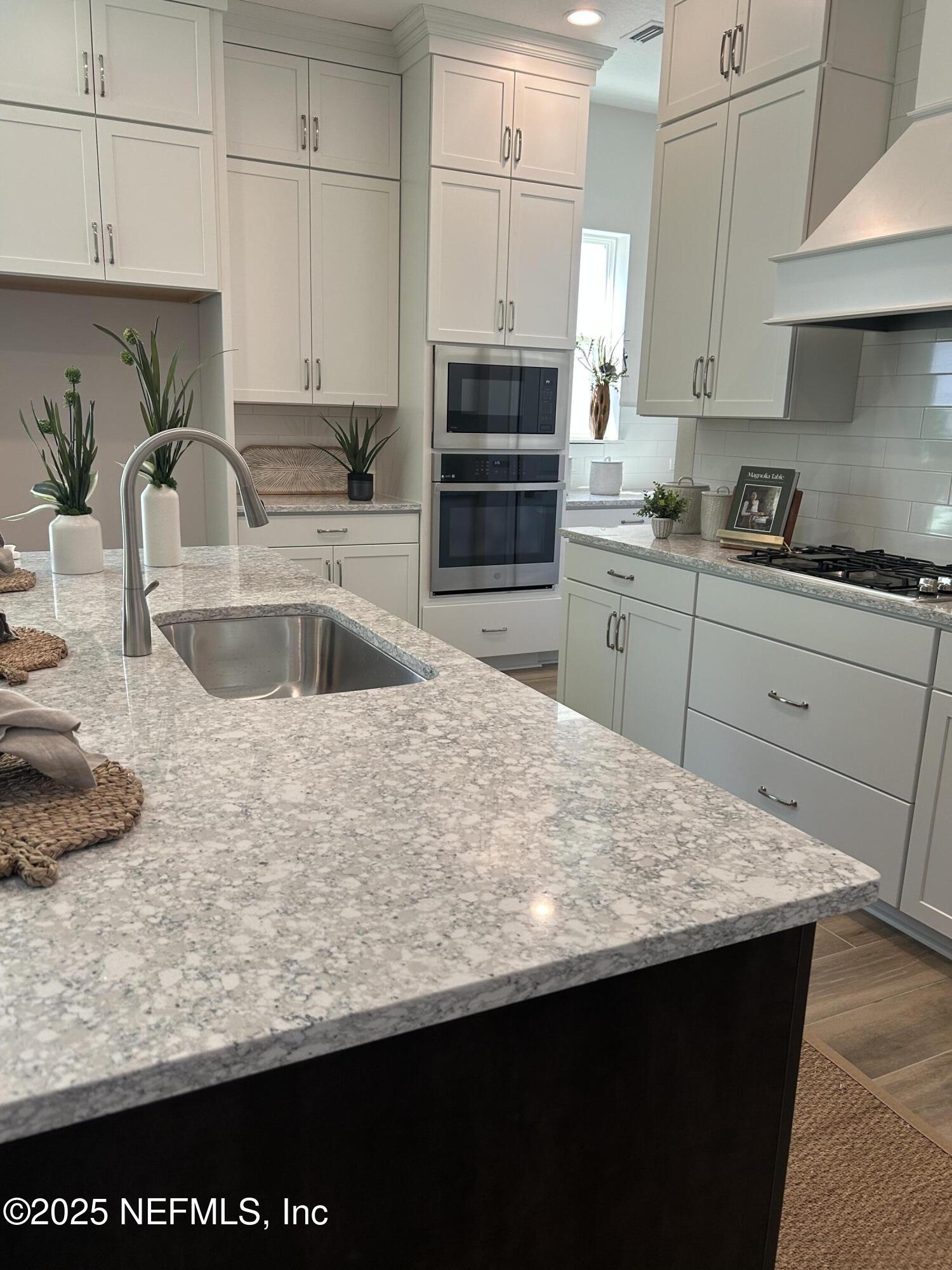 486 Navigators Road St. Johns, FL 32259 - Photo 7 of 22 a kitchen with kitchen island granite countertop a sink a stove and a microwave