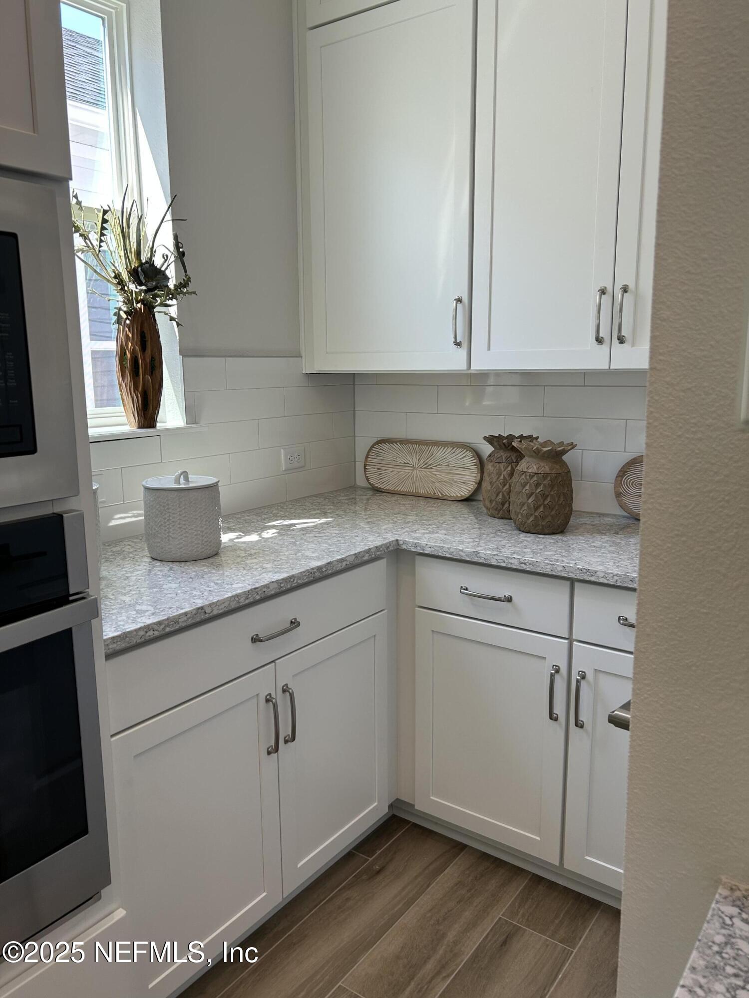 486 Navigators Road St. Johns, FL 32259 - Photo 10 of 22 a kitchen with granite countertop white cabinets and white appliances