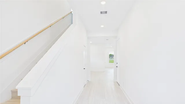 a view of a hallway with wooden floor