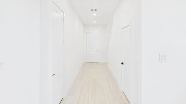 an empty room with kitchen view and windows