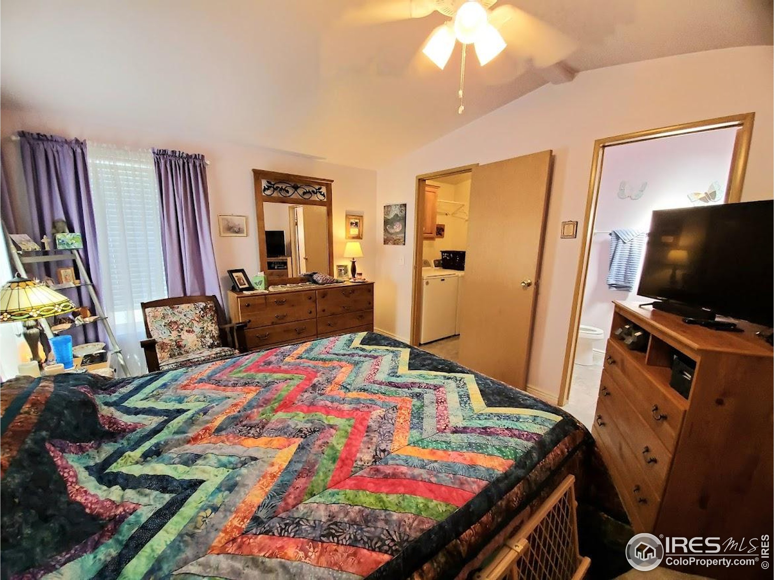 605 West 57th Street, Unit 42 Loveland, CO 80538 - Photo 13 of 38 a bedroom with a bed and flat screen tv