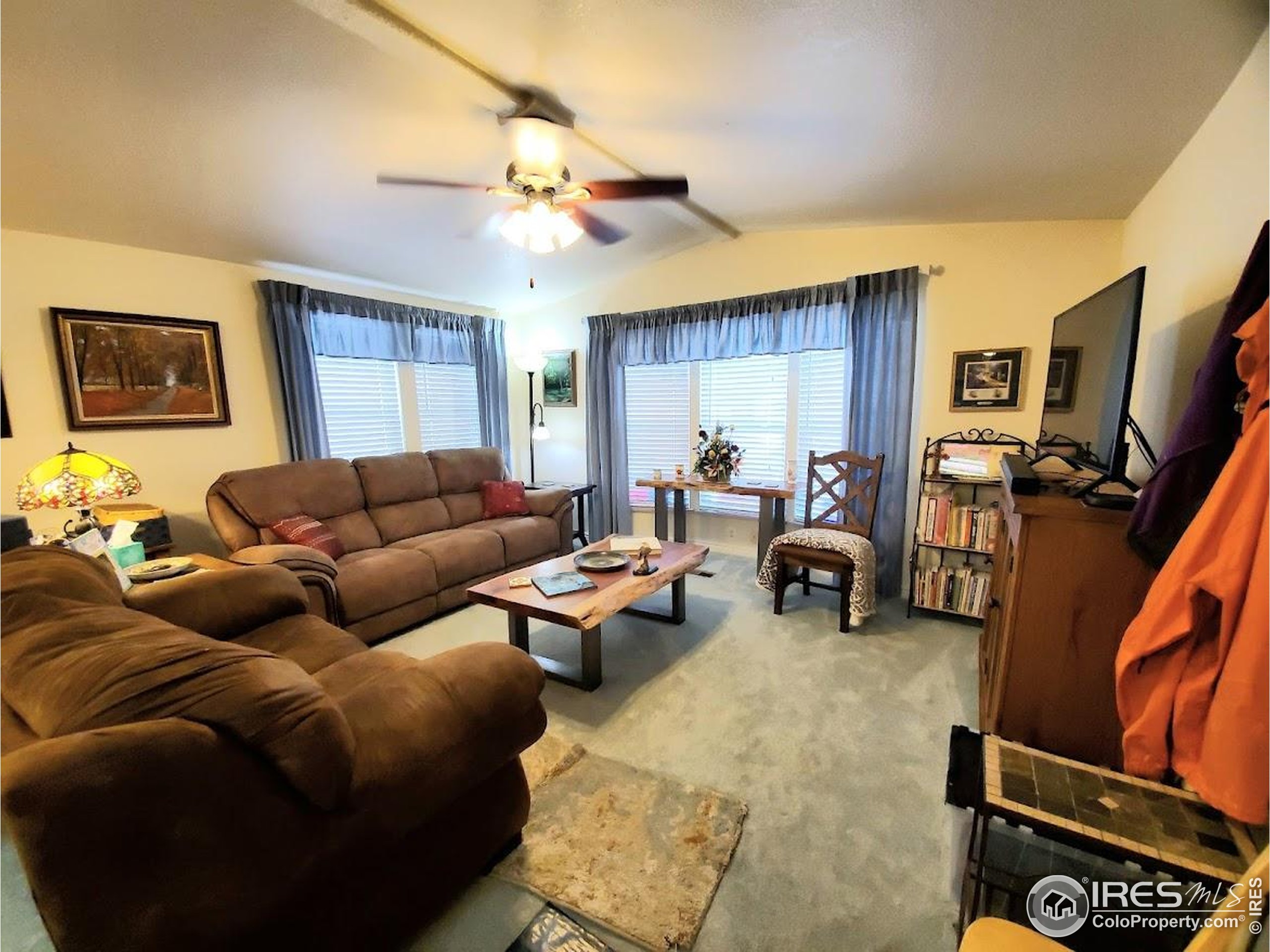 605 West 57th Street, Unit 42 Loveland, CO 80538 - Photo 3 of 38 a living room with furniture and a flat screen tv
