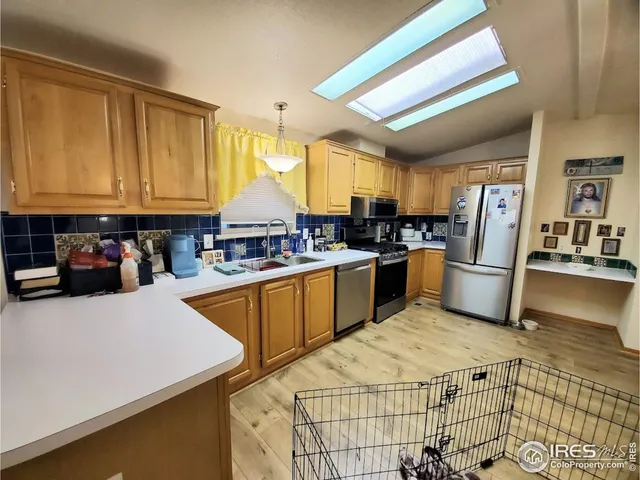 a kitchen with stainless steel appliances wooden cabinets a sink and a refrigerator