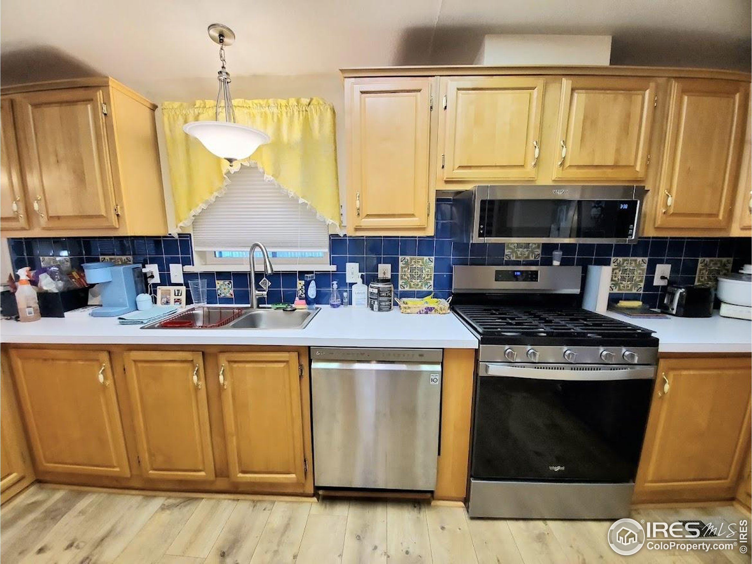 605 West 57th Street, Unit 42 Loveland, CO 80538 - Photo 9 of 38 a kitchen with stainless steel appliances granite countertop a stove a sink and a microwave