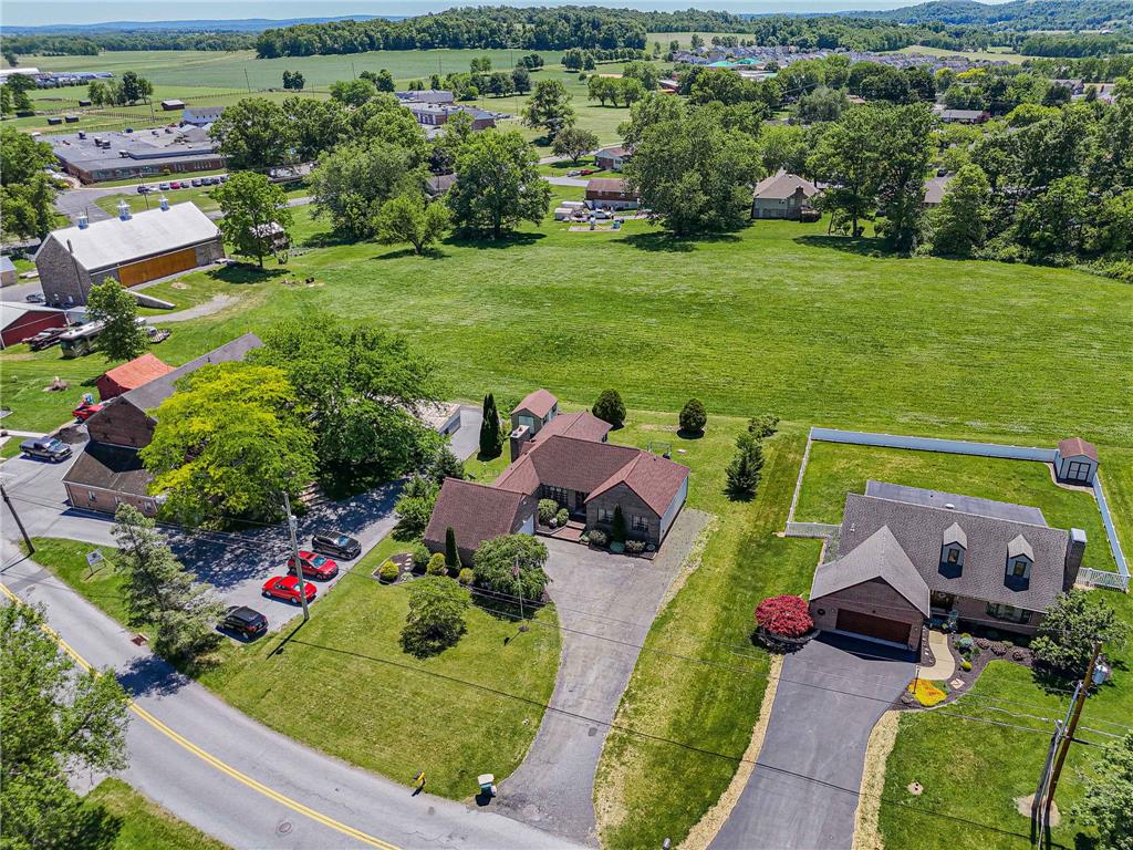 652 Old State Road Oley, PA 19547 - Photo 4 of 54 An aerial perspective reveals a charming property set against a backdrop of rolling hills and lush green fields.