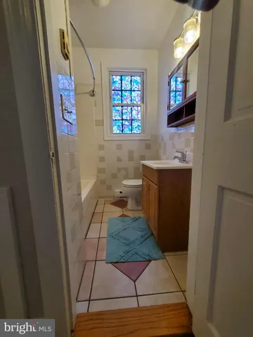 a view of bathroom with mirror on the wall and a window