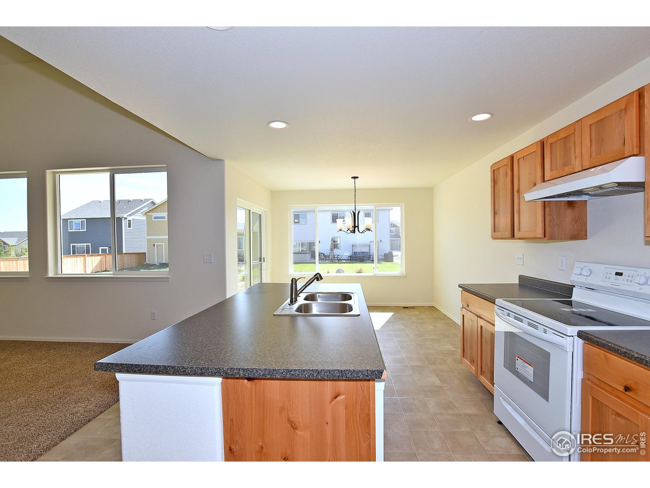 2270 Sublime Drive Windsor, CO 80550 - Photo 16 of 39 a kitchen with kitchen island granite countertop a sink cabinets and window