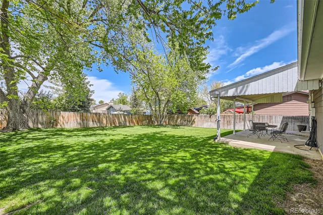 a view of a backyard with table and chairs under an umbrella
