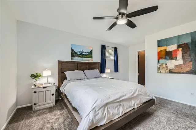 a bedroom with a bed chandelier and a window