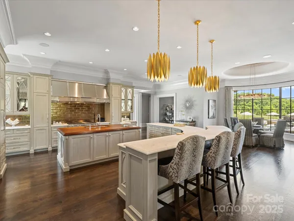 a large white kitchen with a large window and furniture