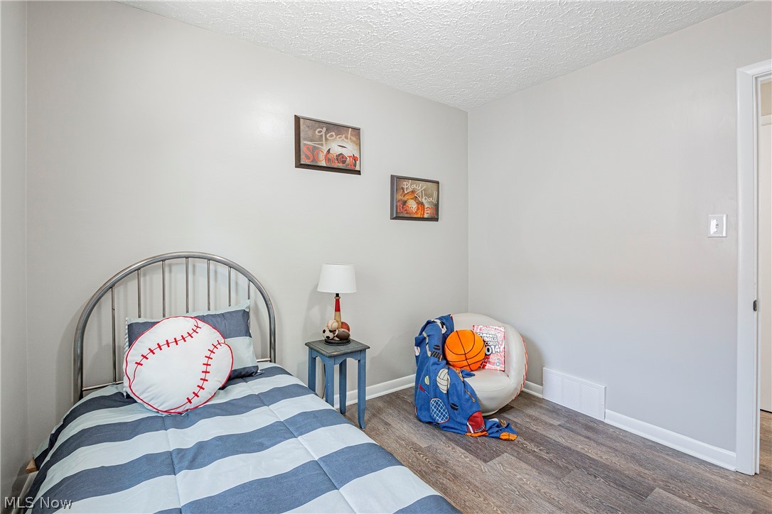 421 Hillman Road Akron, OH 44312 - Photo 19 of 27 Bedroom featuring a textured ceiling and hardwood / wood-style floors