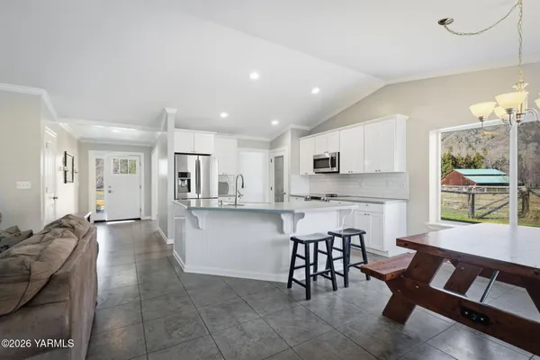 a living room with stainless steel appliances kitchen island granite countertop furniture and a kitchen view