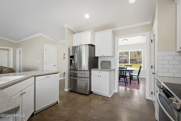 a kitchen with white cabinets and stainless steel appliances