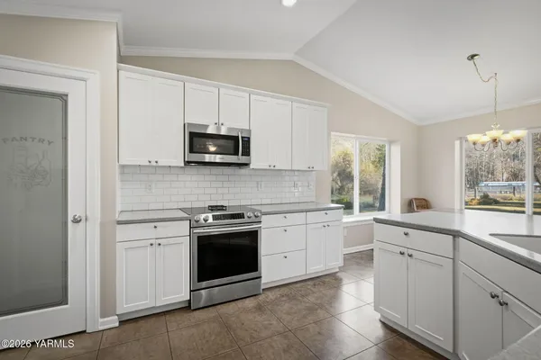 a kitchen with white cabinets and appliances