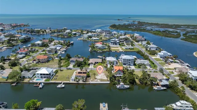 an aerial view of ocean and residential houses with outdoor space