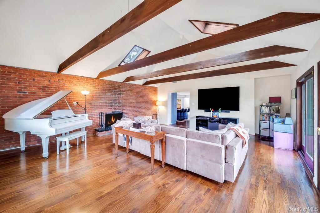 39 Bevin Road Northport, NY 11768 - Photo 19 of 44 Living area featuring brick wall, wood finished floors, and a brick fireplace