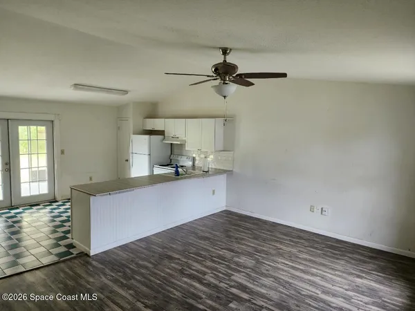 a kitchen with a wooden floor and cabinets