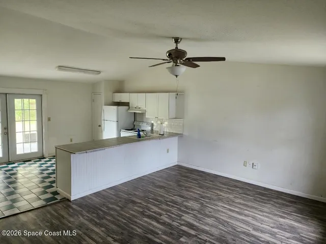 a kitchen with a wooden floor and cabinets