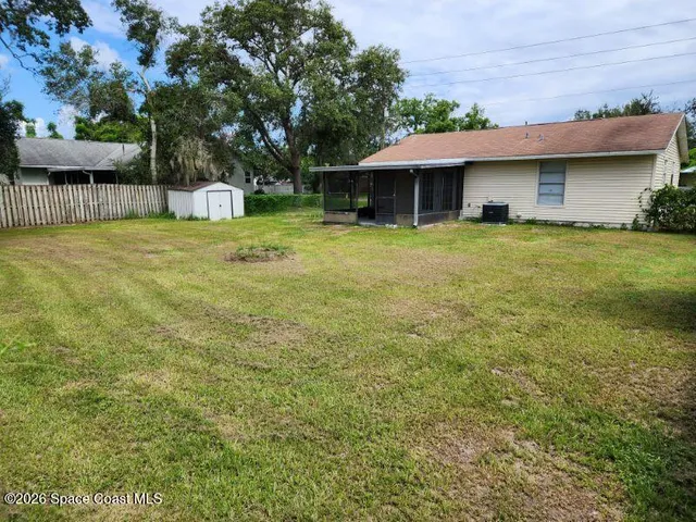 a front view of a house with a garden and trees