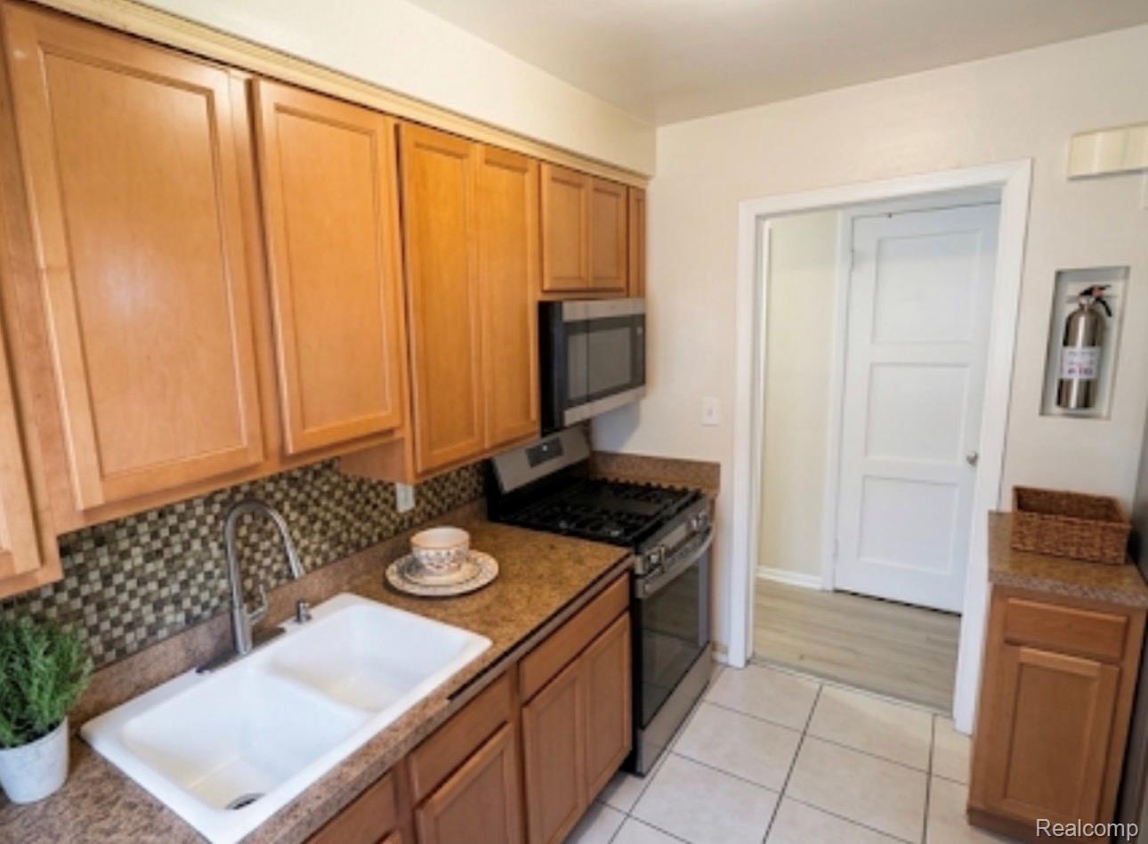 18418 Edinborough Road Detroit, MI 48219 - Photo 8 of 25 Kitchen with stainless steel appliances, light tile patterned flooring, and wood finish cabinets