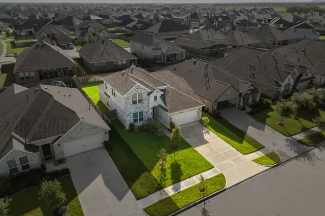 an aerial view of a house with a garden and swimming pool