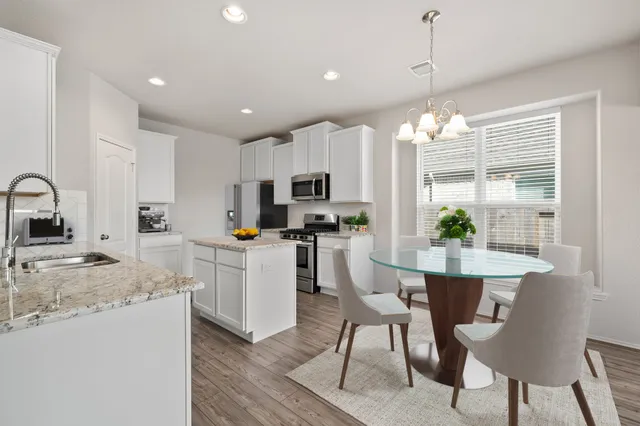a kitchen with cabinets a sink dishwasher and a stove with wooden floor