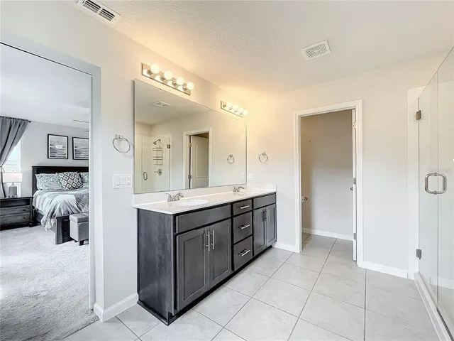 a spacious bathroom with a double vanity sink mirror and shower