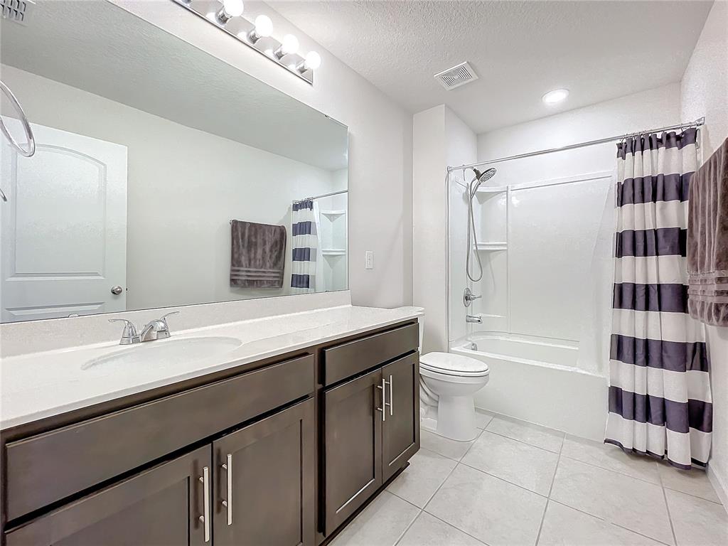 8060 Cherrystone Street Leesburg, FL 34748 - Photo 22 of 30 a bathroom with a double vanity sink toilet mirror and shower