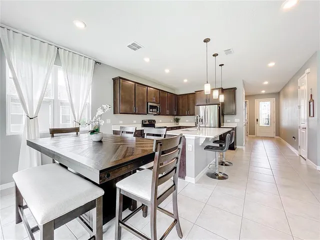 a kitchen with a table chairs refrigerator and microwave