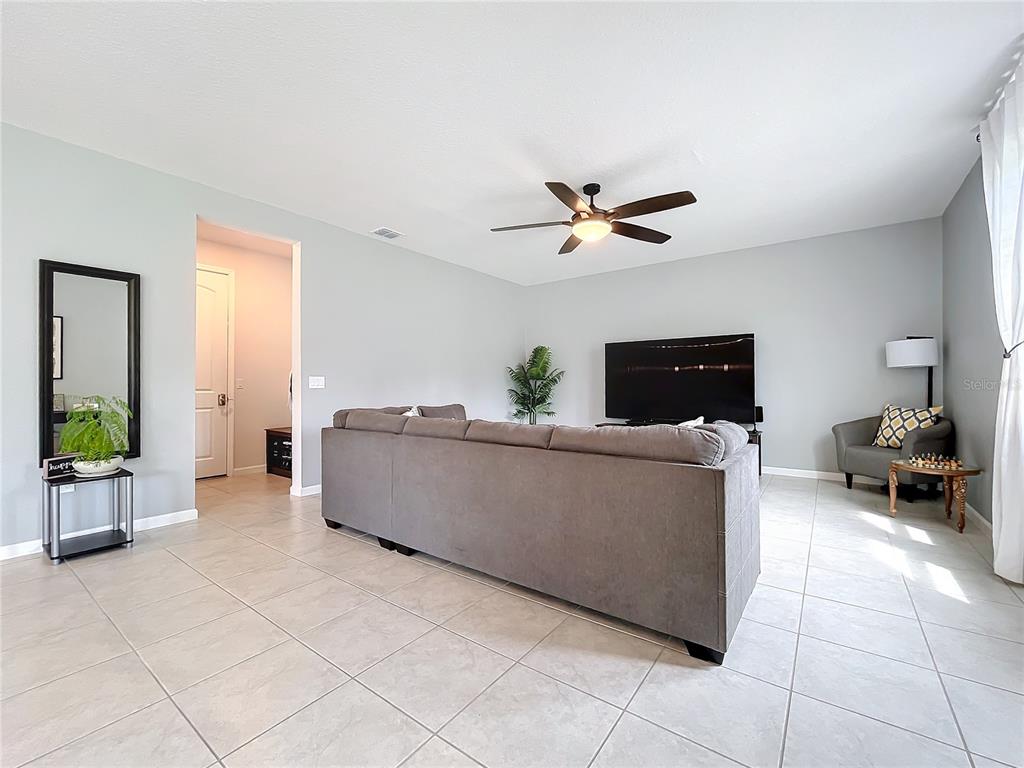 8060 Cherrystone Street Leesburg, FL 34748 - Photo 10 of 30 a living room with furniture and a flat screen tv