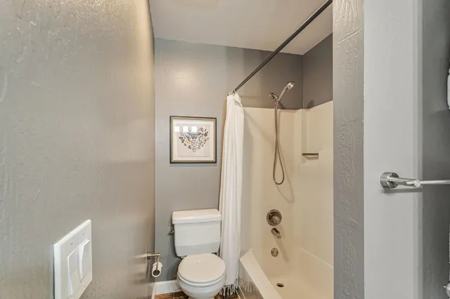 a bathroom with a shower a toilet and a shower