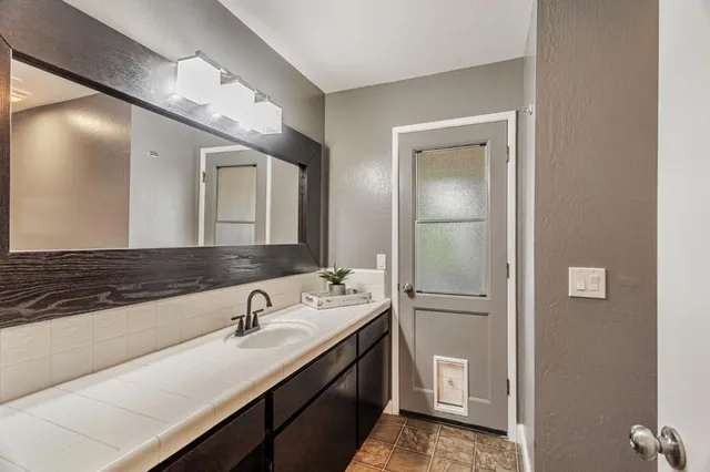 a bathroom with a sink a toilet and mirror