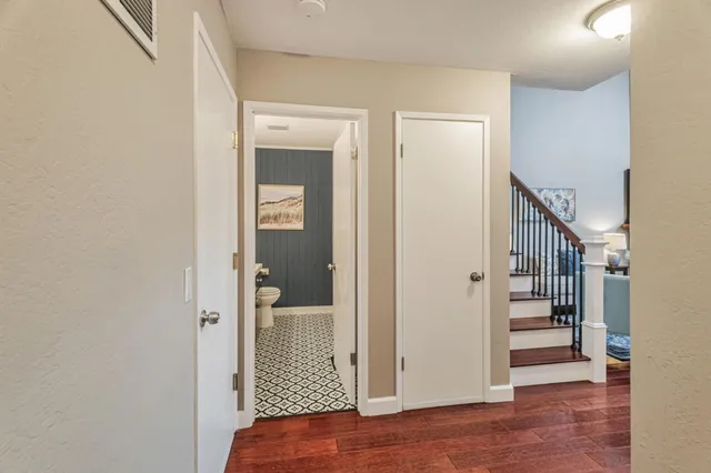 a view of a hallway with wooden floor and staircase