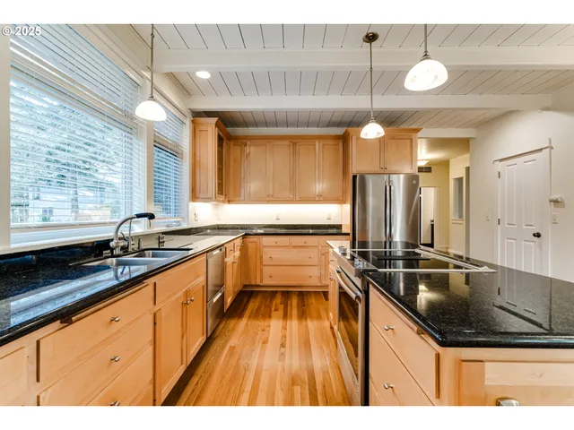 a kitchen with kitchen island granite countertop a sink and a stove