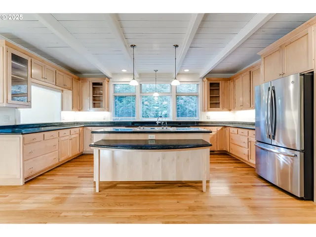 a kitchen with stainless steel appliances granite countertop a stove a sink and a refrigerator
