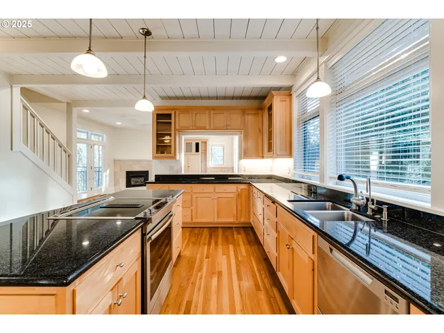 a kitchen with granite countertop a sink stove and cabinets