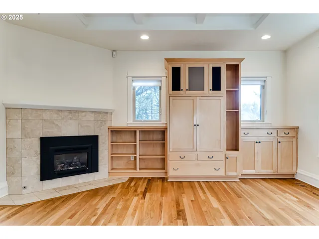 a view of empty room with wooden floor and fireplace