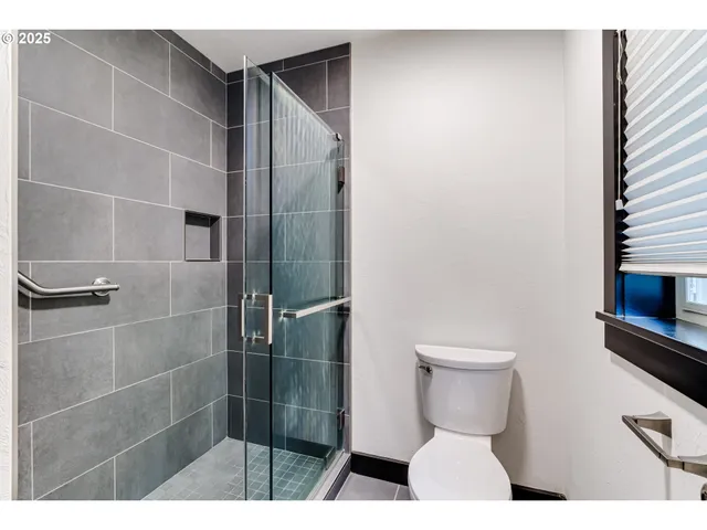 a bathroom with a toilet and a shower