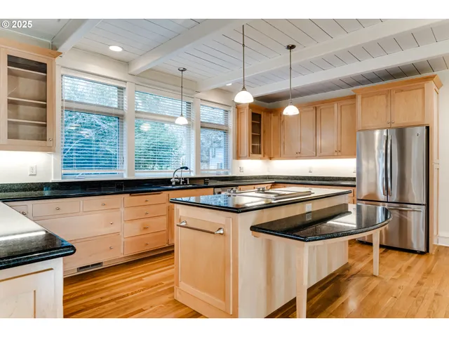 a kitchen with stainless steel appliances granite countertop a stove a refrigerator and a microwave