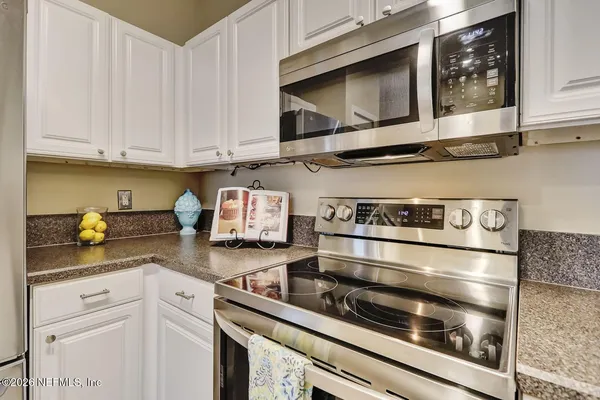 a kitchen with stainless steel appliances granite countertop a stove and a microwave