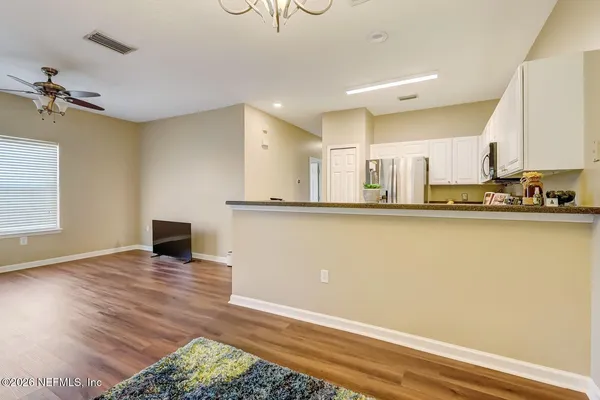 a view of a kitchen with wooden floor and a sink