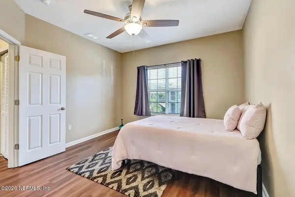 a bedroom with a bed and wooden floor