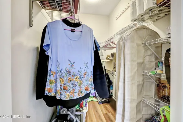 a view of walk in closet with clothes