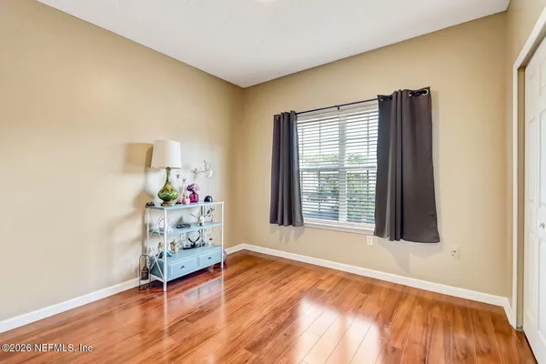 an empty room with a window and wooden floor